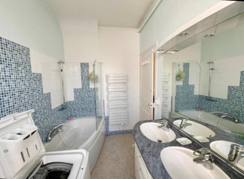 een badkamer met twee wastafels en een ligbad en een tubermott bij Le Coquelicot - Centre - 8 Personnes - Parking in Le Mans