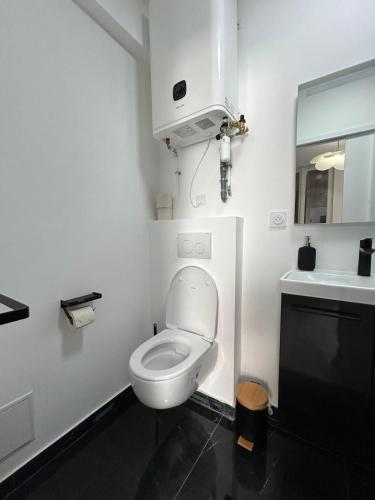 une salle de bain blanche avec toilettes et lavabo dans l'établissement Charming Cozy Studio in Saint-Denis-Stade de France, à Saint-Denis