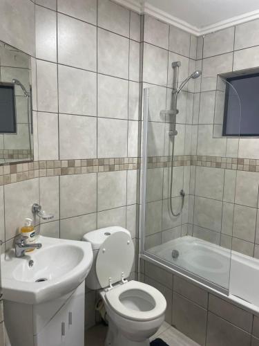 a bathroom with a toilet and a sink and a shower at Blouberg Beach Gem 5 Min Walk in Cape Town