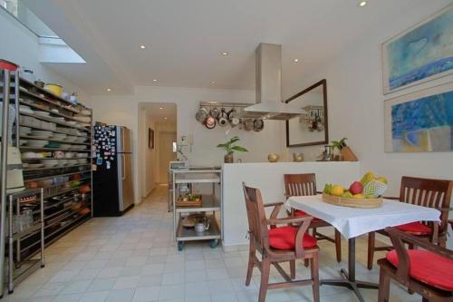 une cuisine et une salle à manger avec une table et des chaises dans l'établissement Charmosa casa 4 suítes no Jd Europa, à São Paulo