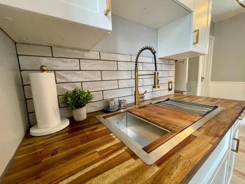 a kitchen with a sink on a wooden counter top at Heritage House Downtown Moncton in Moncton