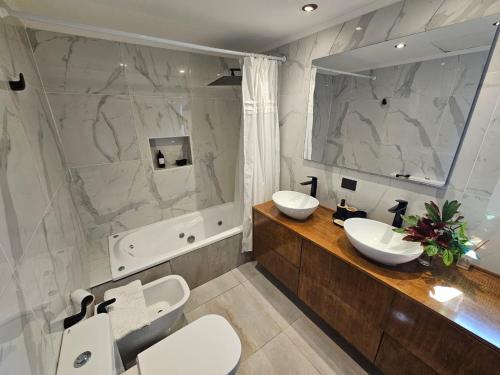 a bathroom with two sinks and a large mirror at CasaDelSUr in San Carlos de Bariloche