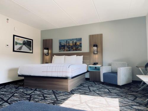 a hotel room with a bed and a chair at La Quinta by Wyndham Atlanta Roswell in Roswell