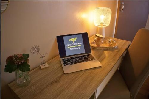 un ordinateur portable assis au-dessus d'une table en bois dans l'établissement La Pause Voyage - chambre privative, gare à proximité, à Bourbourg