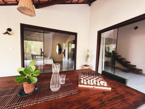 a room with a wooden table with a glass at Casa Gemini in Ilha de Boipeba