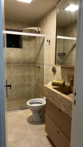 Un baño con inodoro y ducha de cristal. en Conforto moderno na praia, en Itapema