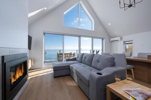 a living room with a couch and a fireplace at Panorama 1253: St. Lawrence View, Spacious Terrace in Petite-Rivière-Saint-François