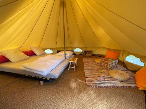 a tent with two beds and two rugs in it at Camping Les Portes de Sancerre in Saint-Satur
