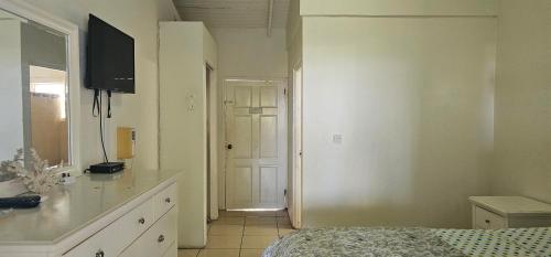 Un dormitorio con una cama y una puerta a un pasillo. en Wavecrest Suites, en Grand Anse