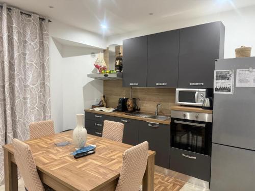 a kitchen with a wooden table with chairs and a refrigerator at aphrodite's apartment ad Aspra in Bagheria