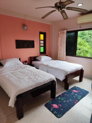 a bedroom with two beds and a ceiling fan at Town View Hostel - Krabi Town in Krabi town