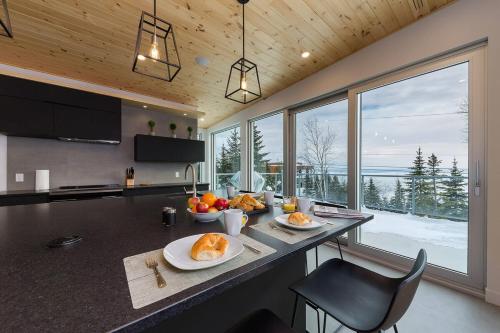 a kitchen with a counter with plates of food on it at Le Rupin 77: Luxury Contemporary, Spa, River View in Petite-Rivière-Saint-François