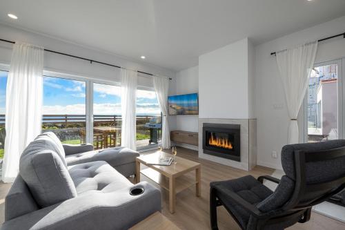 a living room with two couches and a fireplace at Panorama 1249, Majestic River View, Spacious Patio in Petite-Rivière-Saint-François