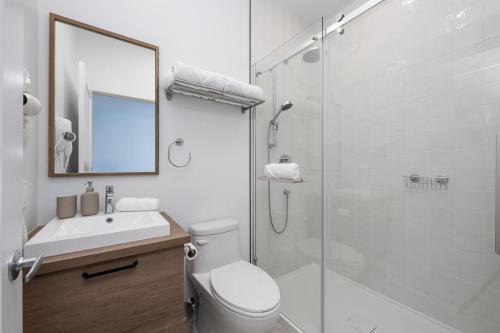 a bathroom with a toilet and a sink and a shower at Panorama 1249: Garden-Level with Fireplace in Petite-Rivière-Saint-François