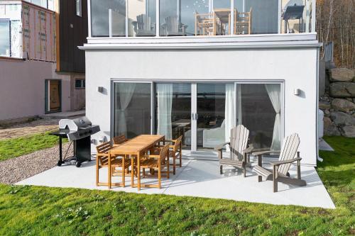 a patio with a table and chairs and a piano at Panorama 1249, Majestic River View, Spacious Patio in Petite-Rivière-Saint-François