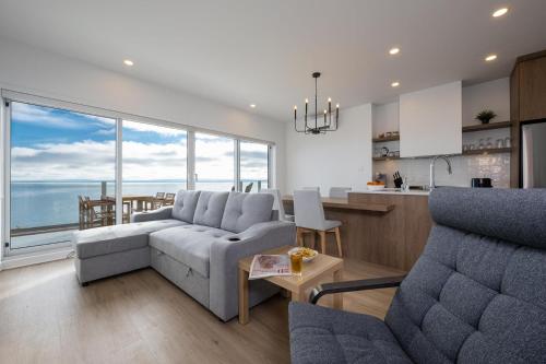 a living room with a couch and a table at Panorama 1251: Private & Luxury, River Sunsets in Petite-Rivière-Saint-François