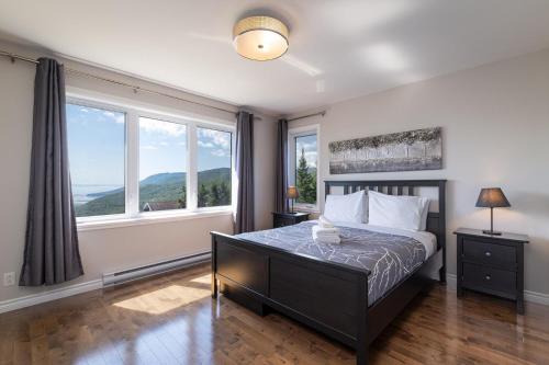 a bedroom with a bed with a large window at Phoenix 75: River view, Spa and Pool Table in Petite-Rivière-Saint-François
