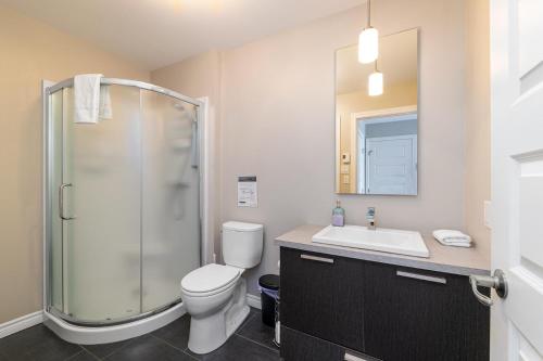 a bathroom with a shower and a toilet and a sink at Phoenix 75: River view, Spa and Pool Table in Petite-Rivière-Saint-François