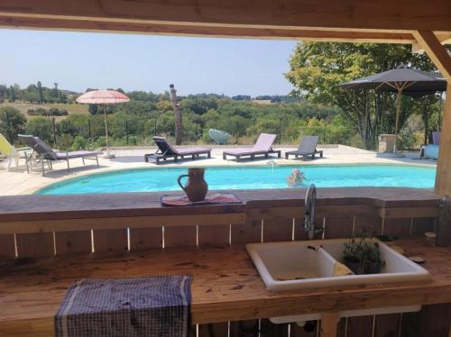 a swimming pool with a sink and a sink at La P'tite Maiz in Bourg-de-Visa
