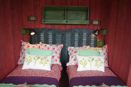 two beds in a room with red walls at L'école est finie ! in Féron