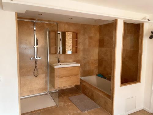a bathroom with a shower and a tub and a sink at Villa Le M in Six-Fours-les-Plages