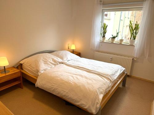 Schlafzimmer mit einem Bett und einem Fenster mit Pflanzen in der Unterkunft Apartment auf zwei Etagen - Casita in Burgstaedt