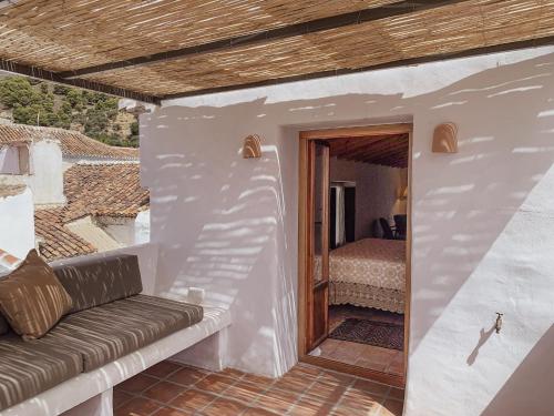 ein Wohnzimmer mit Sofa und ein Schlafzimmer in der Unterkunft Casa Al Zaytun Pueblo in Canillas de Aceituno