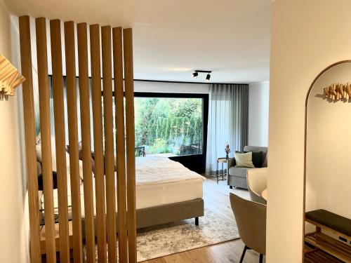 ヘルシング・アム・アンマーゼーにあるPittino Gartensuite 02 in zweiter Seereihe Ammerseeのベッドと大きな窓のある寝室