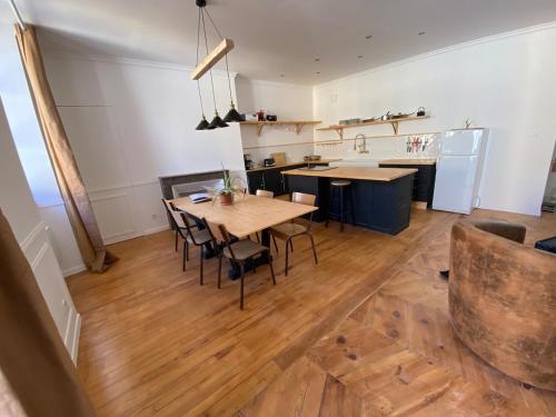 a kitchen with a wooden table and chairs in a room at Appartement lumineux Embrun in Embrun