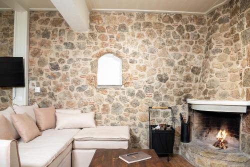 Una sala de estar con un sofá y una chimenea. en Ampolis Guest House, en Arachova