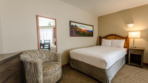 a hotel room with a bed and a chair at Cahilty #346 home in Sun Peaks