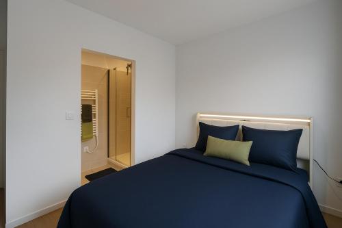 - une chambre avec un lit bleu et une douche à l'italienne dans l'établissement Coliving Henri Barbusse - salle de sport - chambres avec SDB privative, au Mans