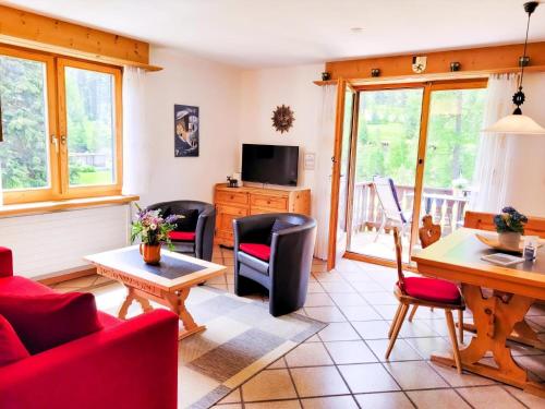 Una sala de estar con un sofá rojo y sillas. en Curtins18, en Pontresina