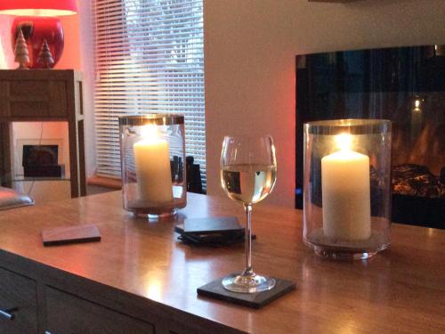 EllonbyにあるLarchwoodのカウンターの上には2本のキャンドルとグラス1杯のワイン