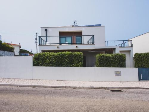 a white building with a balcony on top of it at Villa das Hortas - modern villa at Silvercoast - Portugal in Salir de Porto
