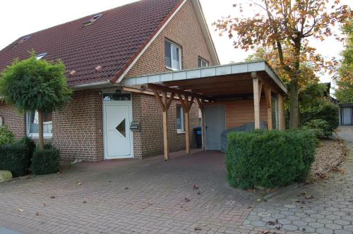 a brick house with a garage with a white door at Wohnung In Reckenfeld Mit Eigener Terrasse in Greven