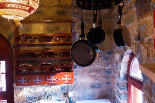 a bunch of pots and pans hanging from a wall at Ferienhaus In Mavrikiano Mit Privatem Pool in Elounda