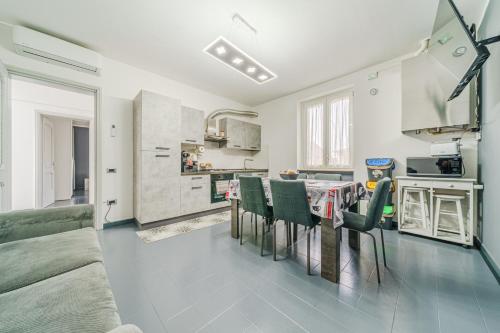 a kitchen and living room with a table and chairs at Casa Francesco - close to the airport & private parking in Azzano San Paolo