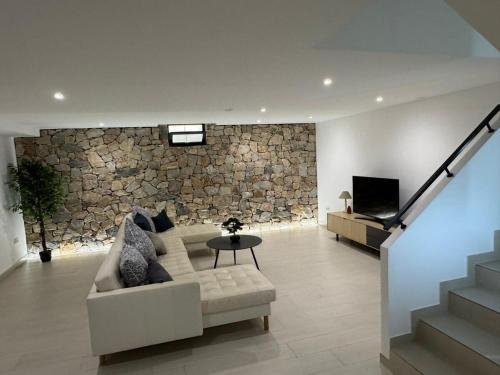 a living room with a couch and a stone wall at Villa in Rojales in Rojales