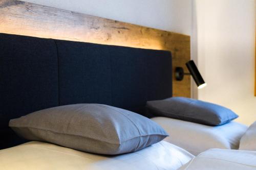 Una cama con cabecero negro y una almohada. en Sonnenhotel Soldanella Sonneck, en Samnaun
