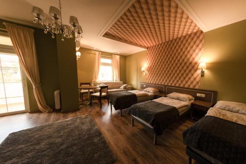 a room with three beds and a table in it at Hotel Granit in Strzegom