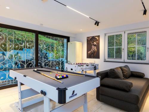 a living room with a pool table and a couch at Waldklang Panorama in Alpirsbach