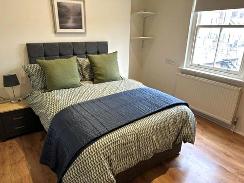 a bedroom with a large bed with green pillows at Three Goats Heads in Oxford