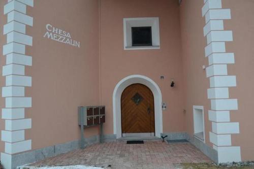 un edificio con una puerta de madera en su lateral en Familie Frei, en Bever