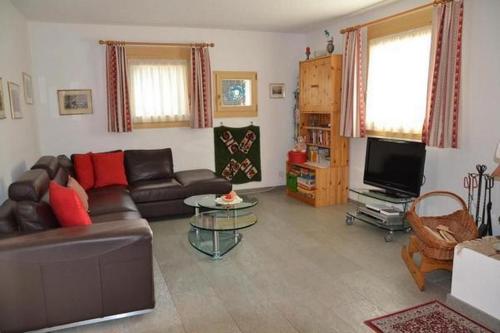 Una sala de estar con un sofá y un televisor. en Familie Frei, en Bever