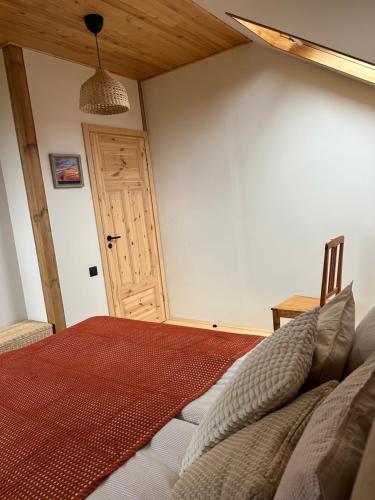 a bedroom with a bed and a wooden door at MūsMājas in Talsi