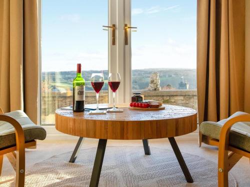 einen Tisch mit zwei Gläsern Wein und ein Fenster in der Unterkunft Frenchgate Cottage in Richmond