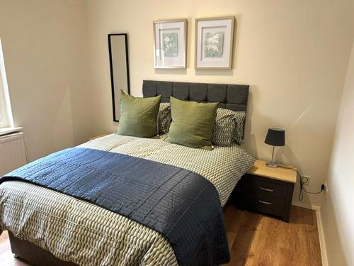 ein Schlafzimmer mit einem Bett mit einer blauen Bettdecke in der Unterkunft Apartment next to The Oxford Union in Oxford