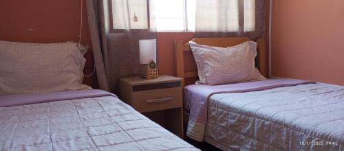 ein kleines Schlafzimmer mit zwei Betten und einem Fenster in der Unterkunft Departamento 5p Tierra del Sol Eterno - Ica centro in Ica