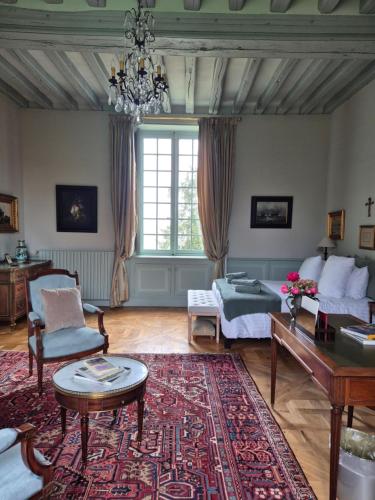 a living room with a bed and a table at Le Petit Serrant - maison d'hôtes d'exception in Bouchemaine
